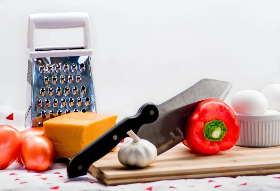 knife, tomatores, eggs, cheese, garlic and food grater
