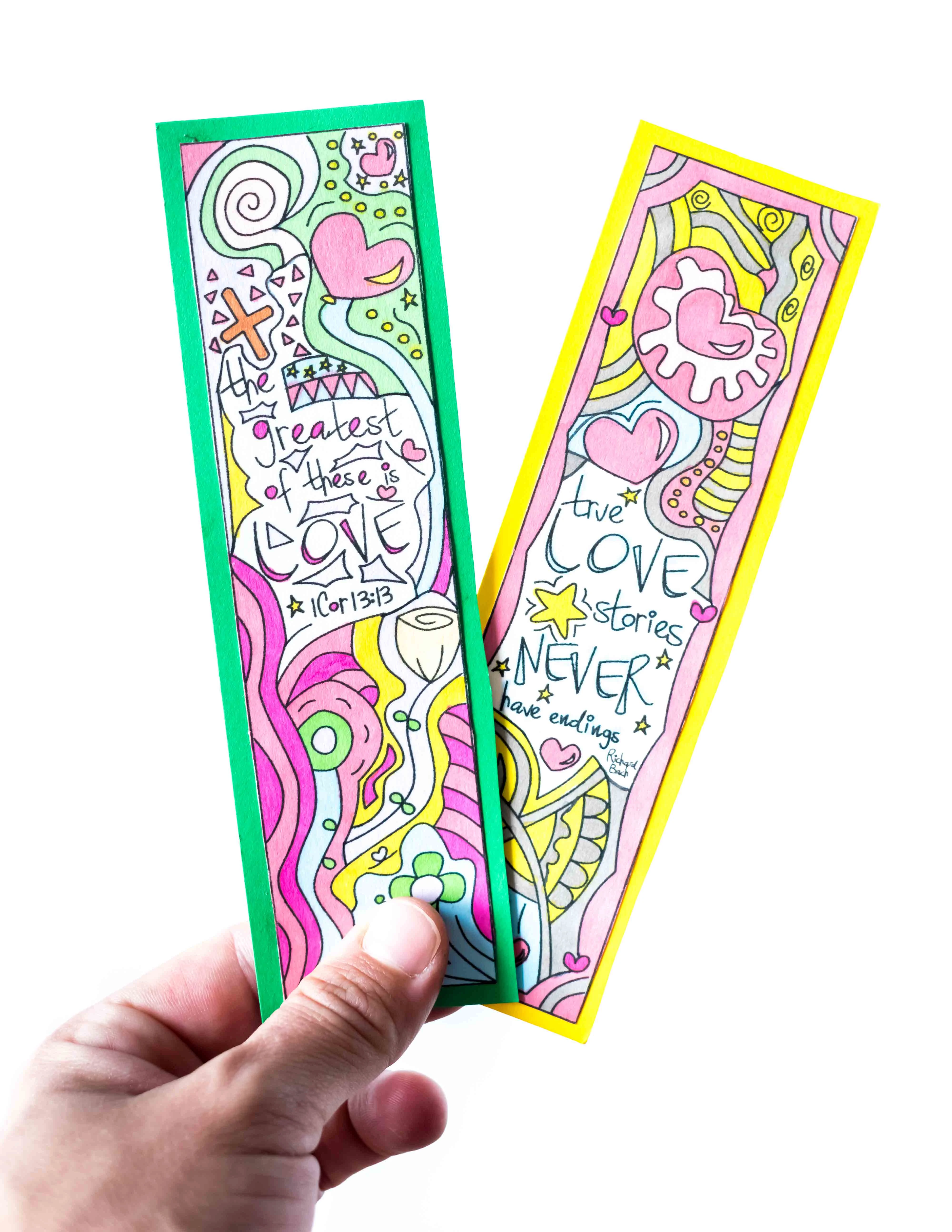 Two Valentine's Day Bookmarks being held in a white background