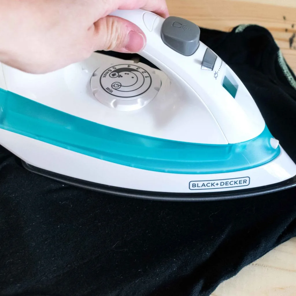 Pressing onesie with Iron t get rid of wrinkles