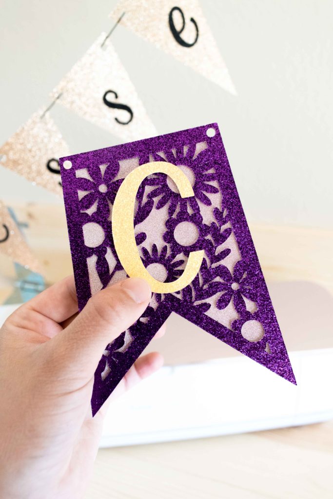 Holding a beautiful purple cut out banner made with Cricut