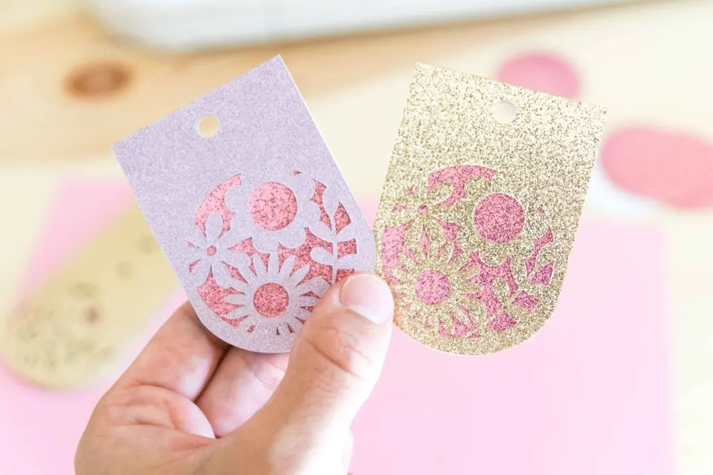 holding fancy gift tags made with Cricut Maker