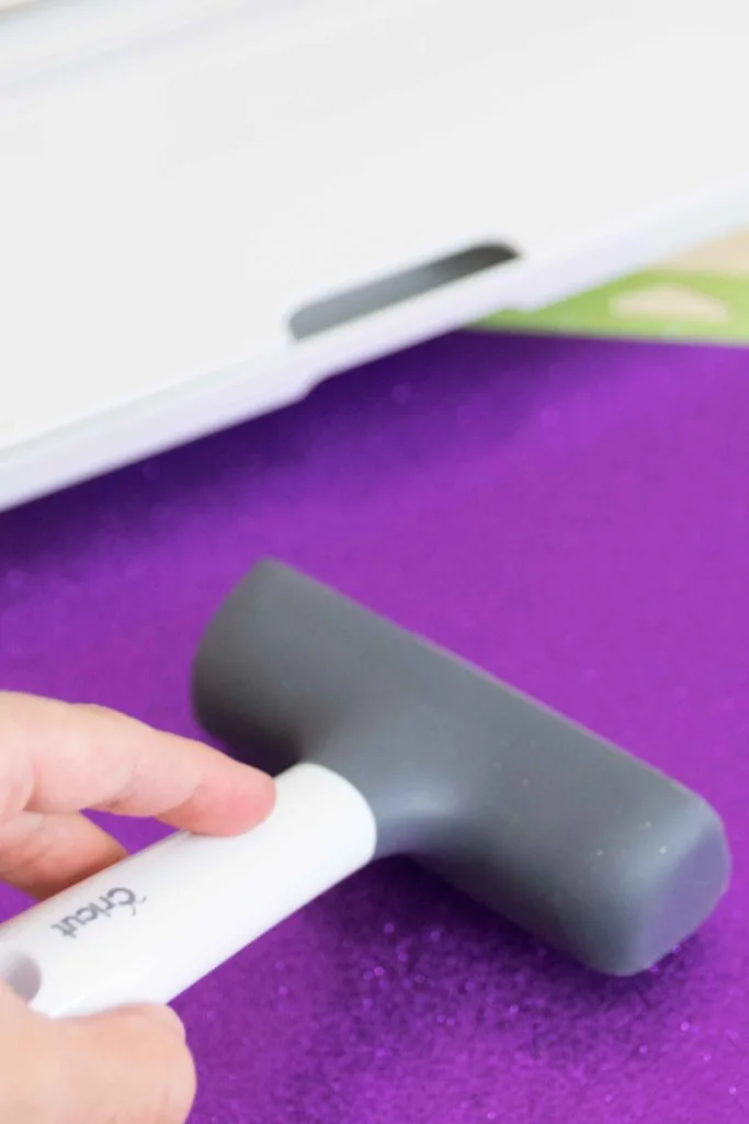 Placing material on Cricut Mat and securing it with the brayer