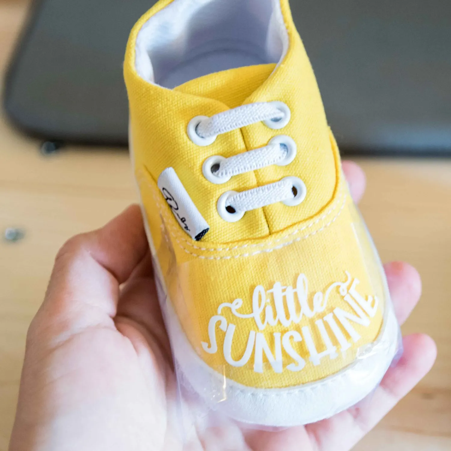 Taping design to baby shoe with heat transfer tape