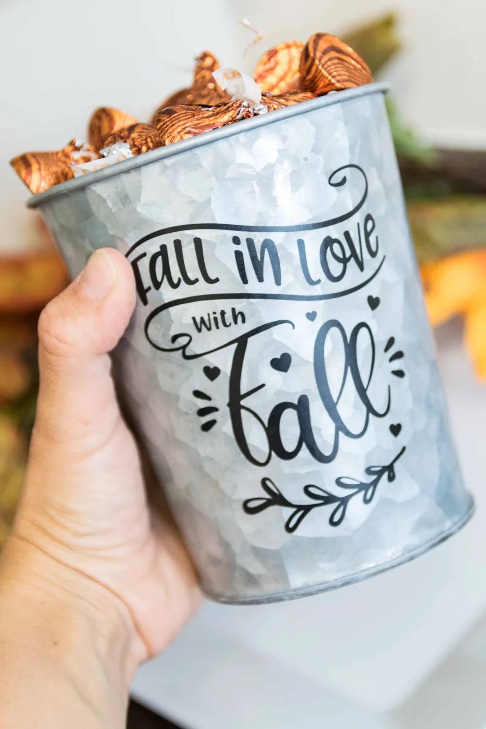 holding a fall-themed decorated candy bucket