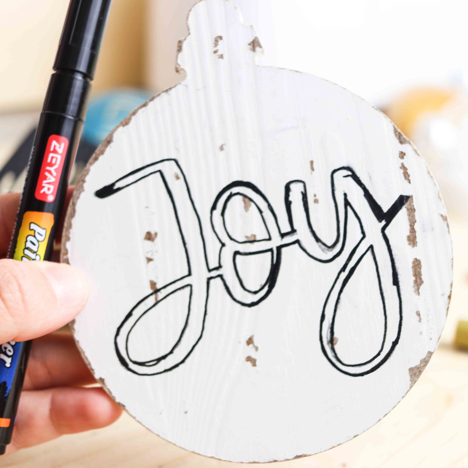 Outlining design on wooden Christmas Ornament