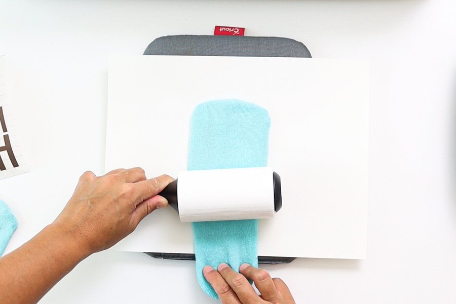 using a lint roller on sock before transferring infusible ink