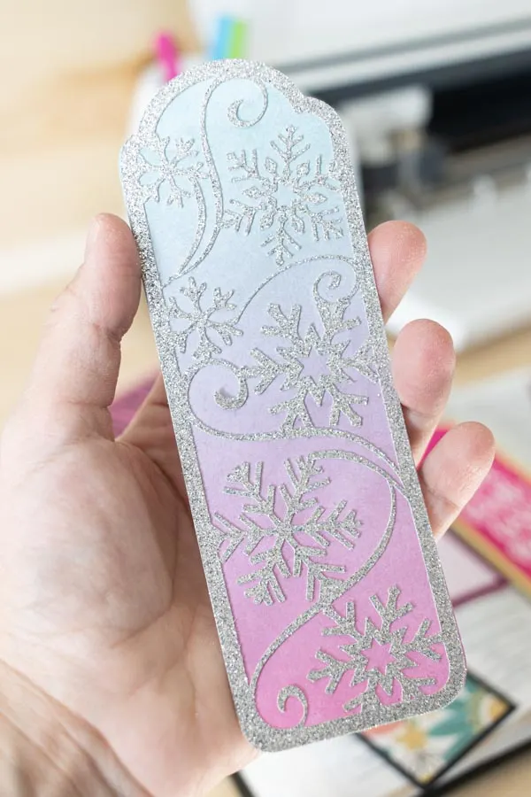 Holding a winter bookmark made with Cricut