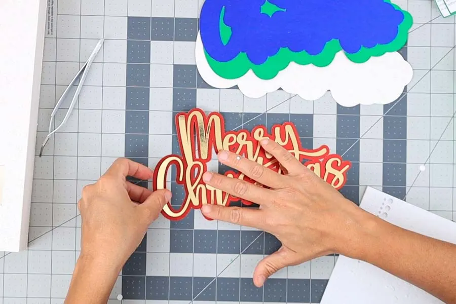 gluing merry Christmas topper for advent calendar with foam dots 2