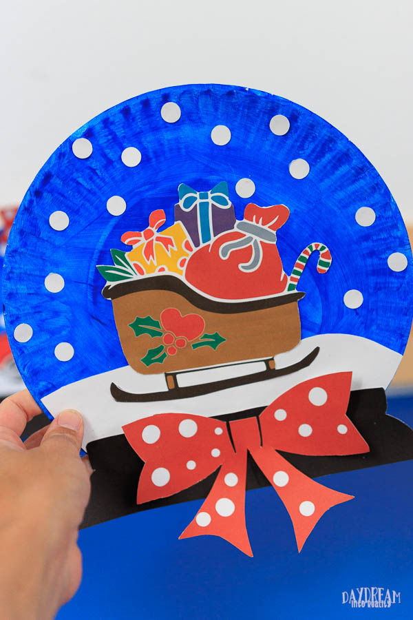 snow globe paper plate craft with a sled