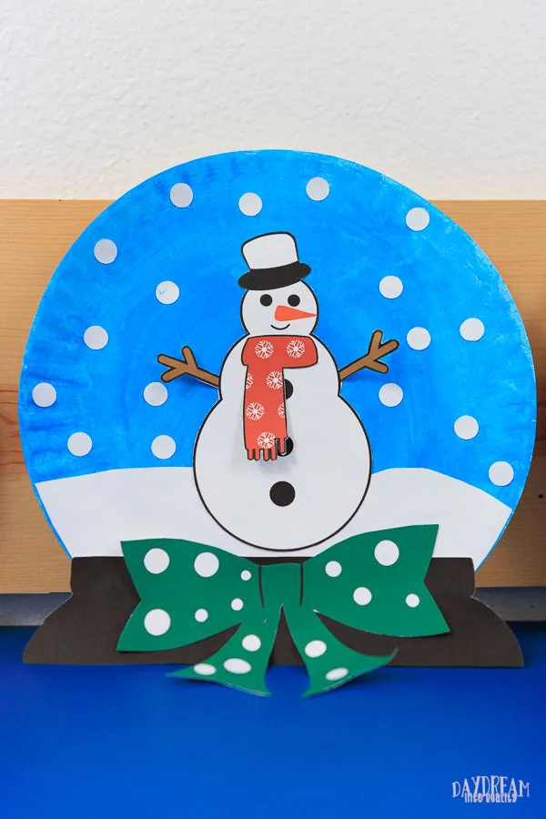 snow globe paper plate craft with a snowman