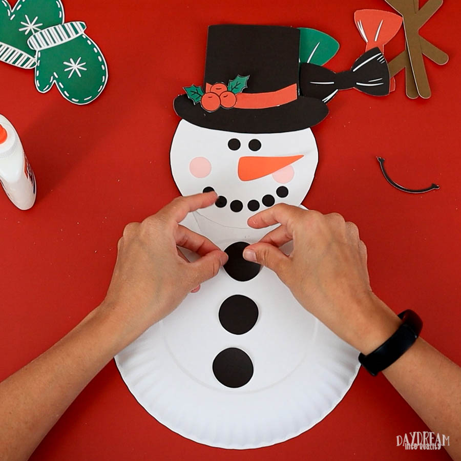 glue buttons to snowman paper plate craft