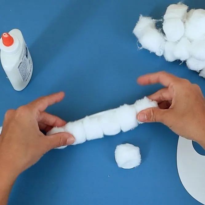 glue cotton balls to Santa's hat.