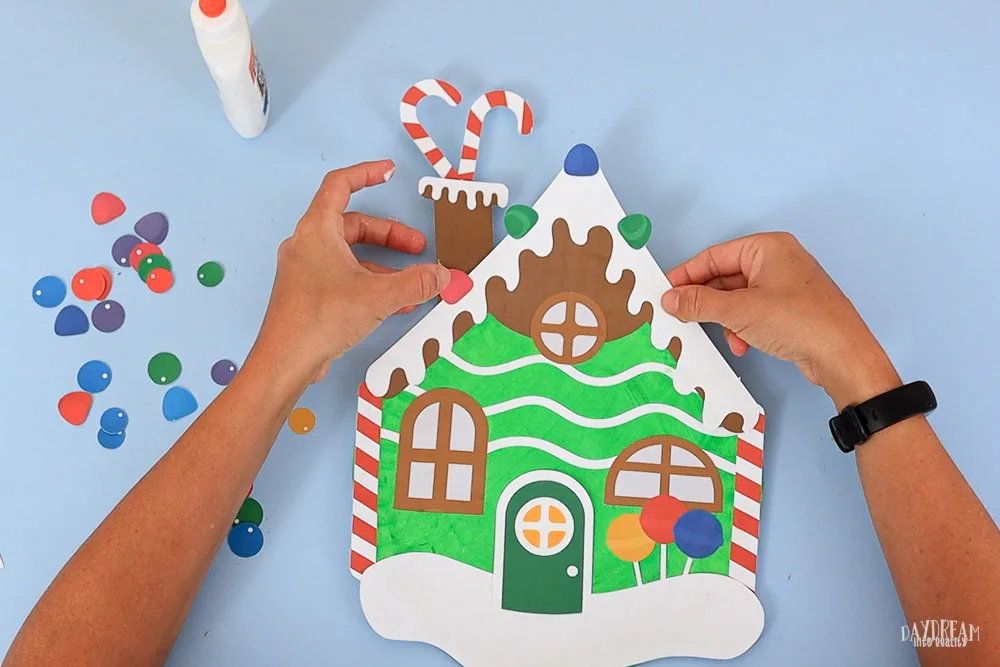 glue gummies and extra candy on gingerbread house